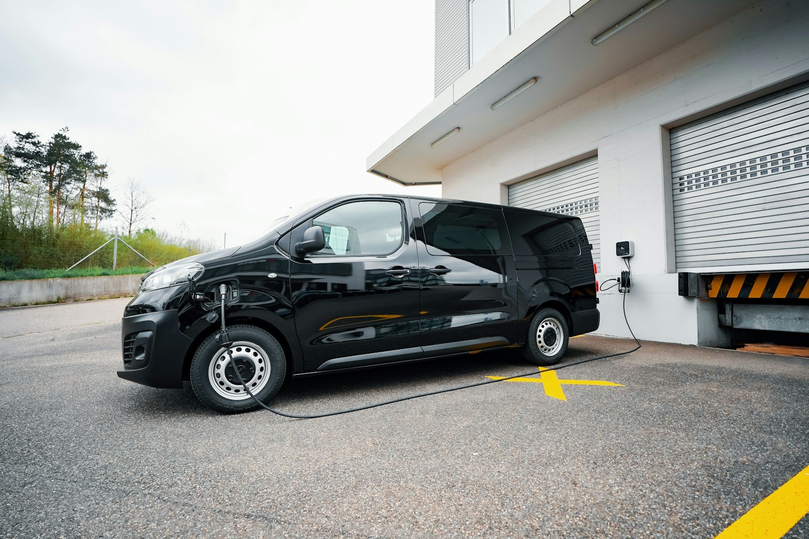A small black car parked in front of a garage