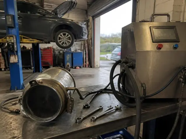 A DPF removed from the vehicle and connected to an off-car cleaning machine in the workshop